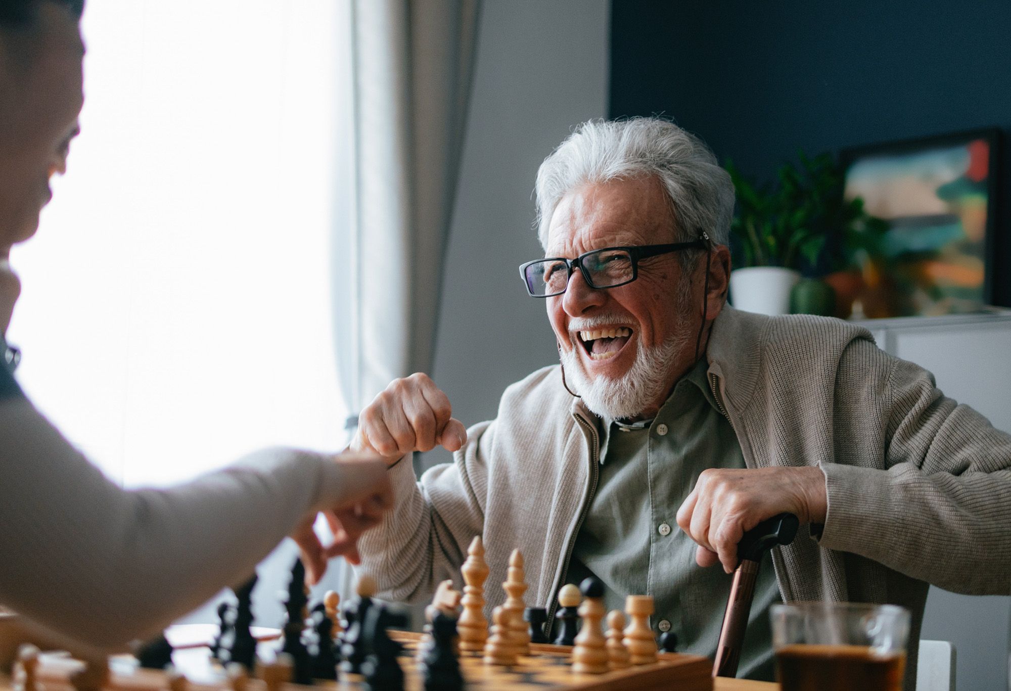 Vieil homme qui joue aux échecs avec son aide à domicile