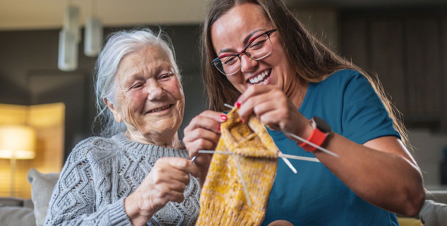 Femme de 70ans et son auxiliaire de vie qui font du tricot